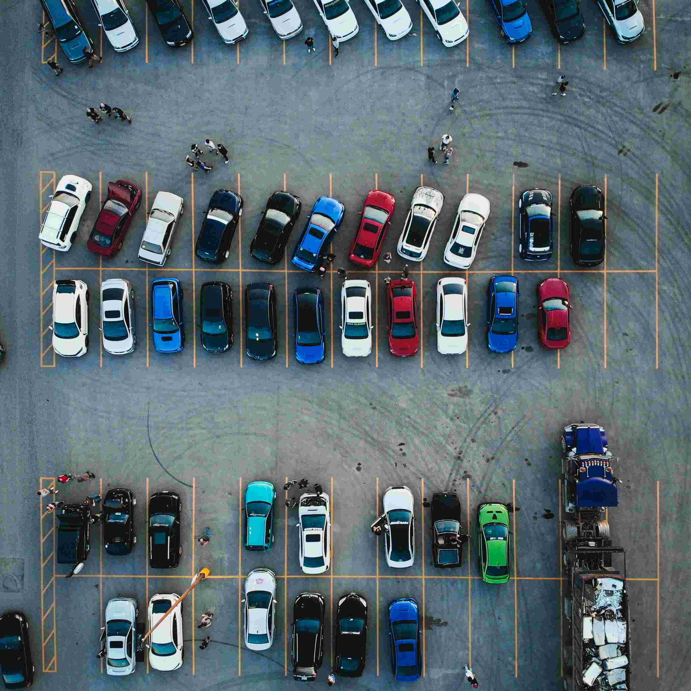 A group of people standing in front of a car